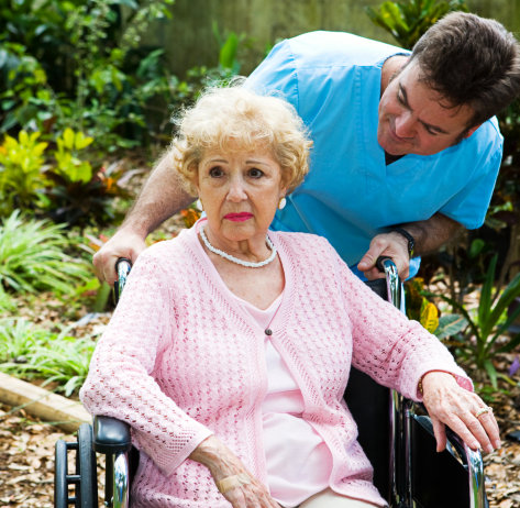 caretaker comforting an elderly woman in a wheelchair