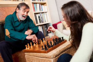elderly man and her daughter playing chess